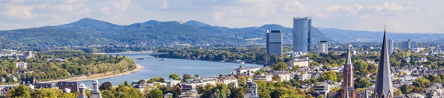 Stadtpanorma am Rhein mit Waldgebirge im Hintergrund in Bonn